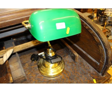 A brass desk lamp with green glass shade