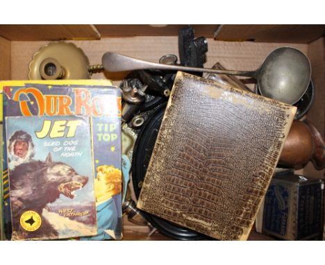 A box containing a silver plated ladle; various other metalware; an oval needlework embroidery etc.