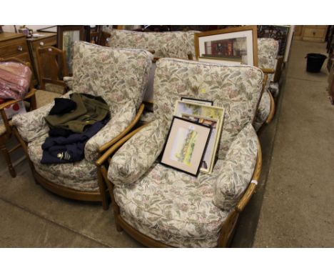 An Ercol three piece suite comprising of a two seater settee and two matching armchairs with footstool