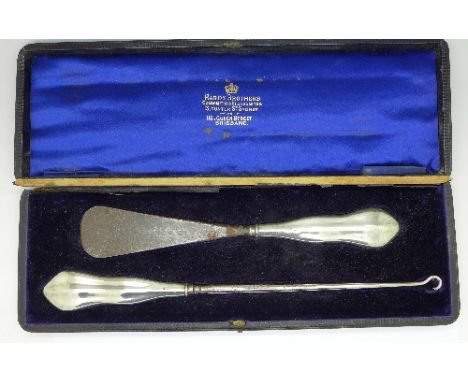 A silver-handled shoe horn and button hook