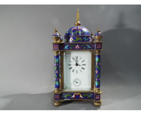 A small Eastern style desk or mantel clock, white enamel dial with Roman numerals, signed M.D.Ger with hour and half-past str