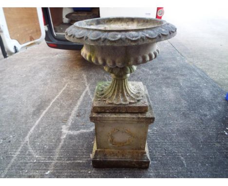 A large reconstituted stone planter on plinth.