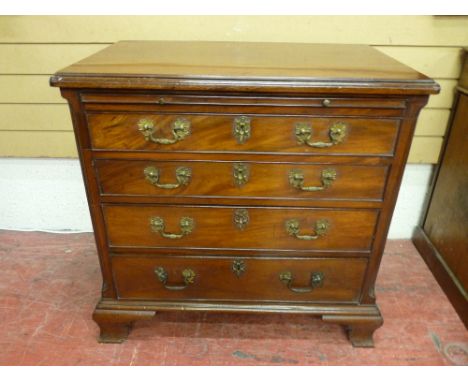 A COMPACT GEORGIAN MAHOGANY BACHELOR'S CHEST of four long graduated drawers all with patterned brass handles and brass escutc