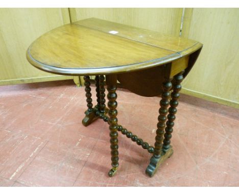 AN EDWARDIAN MAHOGANY OVAL DROP LEAF SUTHERLAND TEA TABLE, with bobbin supports and castors