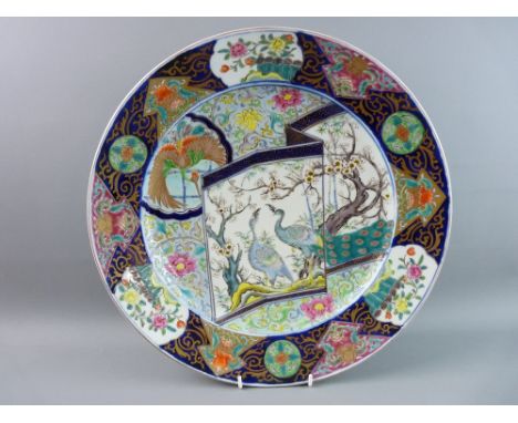 AN EXCELLENT ORIENTAL PORCELAIN WALL CHARGER, 39.5 cms diameter dish shaped with a panelled border of cobalt and gilt decorat