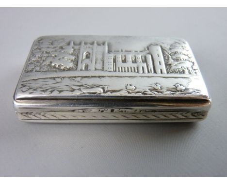 A NATHANIEL MILLS CASTLE TOP SILVER SNUFF BOX of rectangular form with gilt interior showing Newstead Abbey with a lattice de