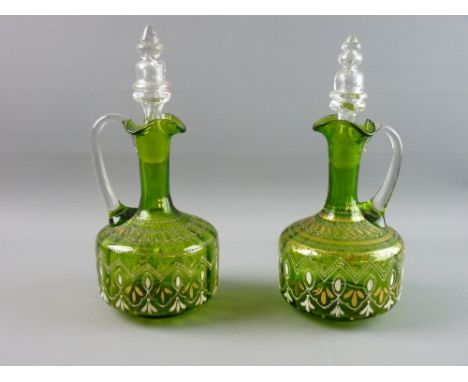 A PAIR OF GREEN GLASS DECANTERS WITH STOPPERS, the bodies with gilt and enamel decoration, 28 cms high