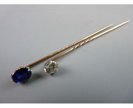 A GOLD TWIST STICK PIN with diamond, estimated 0.5 carat and another gold twist stick pin with oval blue stone