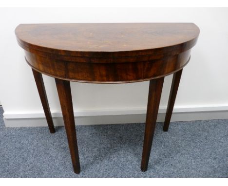 A GEORGIAN MAHOGANY CIRCULAR FOLDOVER CARD TABLE on square tapering supports, 74 cms high, 89 cms wide closed (some polishing