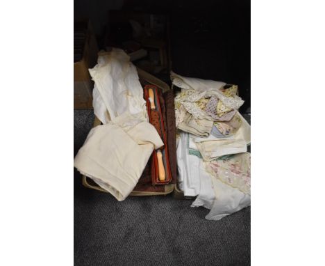 A selection of vintage textiles including table settings and embroidered silk