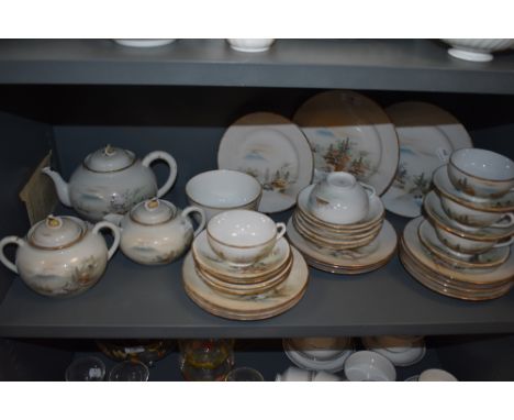 A highly decorated Japanese eggshell china part tea service with mountainous landscape scenes