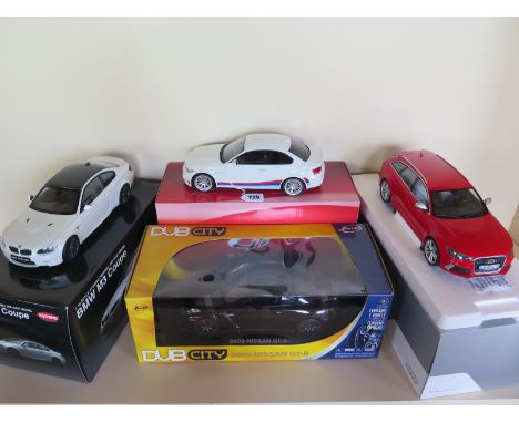 Four 1/18 scale die-cast model cars, including a GT Spirit BMW 1M Coupe No. 747/1500, an Audi RS 6 Avant, a Kyosho BMW M3 Cou