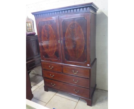 A 19th century mahogany linen press with two doors enclosing two sliding shelves above too short and two long drawers on brac