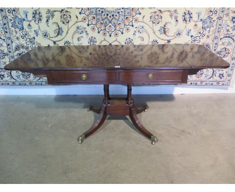 A 19th Century drop leaf sofa table with with two active and two dummy drawers on a quartrefoil outswept base with restoratio