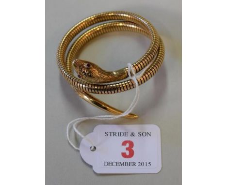 A 9ct gold articulated snake bangle, set ruby eyes. Condition Report: Total weight:  28.4g.  This weight includes metal core.
