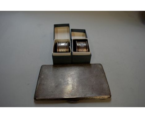 An engine turned silver cigarette case and two cased silver napkin rings, by Viners, 263g.