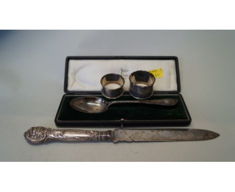 A cased silver dessert spoon, by Walker & Hall; together with two silver napkin rings and a silver handled bread knife, 87g w