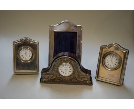 Three silver mounted clocks, by R Carr; and a small silver mounted photograph frame.