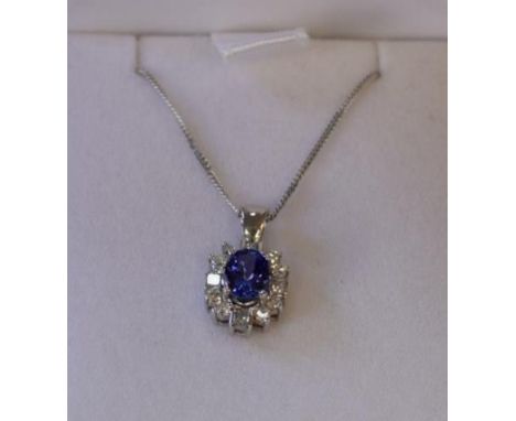 An 18k white gold tanzanite and diamond pendant on fine 18ct white gold curb chain necklace.