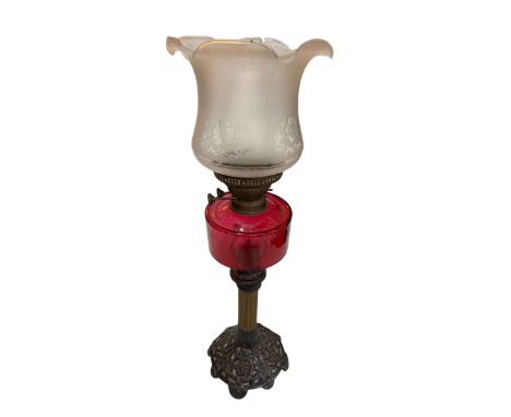 Victorian cast metal and brass oil lamp with ruby reservoir and frosted etched shade.