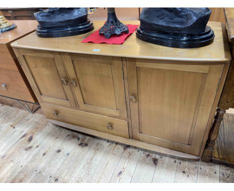 Ercol Windsor sideboard having three doors and a base drawer, with two internal adjustable shelves and partitioned drawer. 69