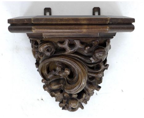 A carved wooden wall bracket, early 20th century, carved in high relief with foliate scrolling decoration, 30 by 21 by 26cm h