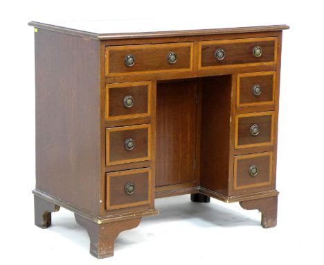 A reproduction kneehole desk, in late Georgian style, eight drawers with ring handles, brown leatherette surface, raised on b