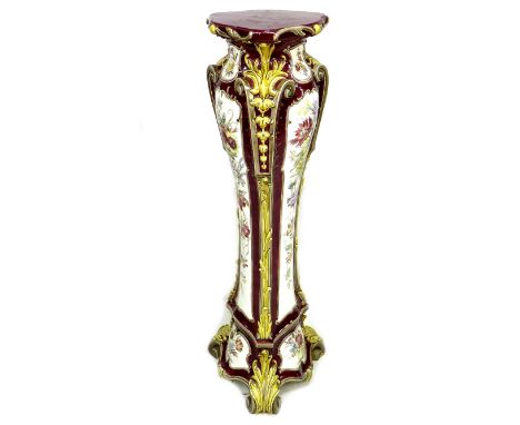 A Victorian ceramic pedestal, in Rococo style with three bombe sides and moulded foliate decoration, glazed in burgundy with 