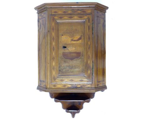 A Continental early 19th century mahogany corner cupboard, single flat fronted door to canted sides marquetry inlaid with a s