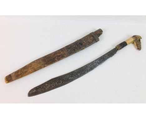 A Dayak mandau sword Borneo, Indonesia, the curved steel blade with engraved decoration to each side, with scrolled notch abo