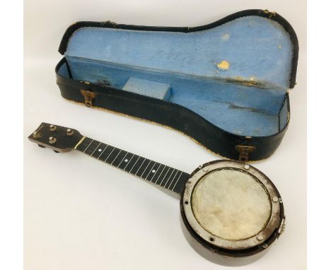 A vintage British made 1920's ukulele banjo, with hide within a wooden frame with mother of pearl inlay, a/f in need of some 