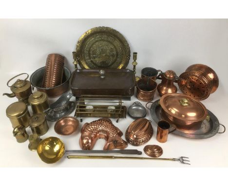 A collection of copper, brass, and metal wares, including fish form jelly mould, brass ladle, lidded casserole dishes, trays,