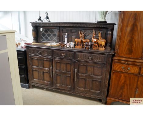 An Ercol court cupboard fitted three drawers