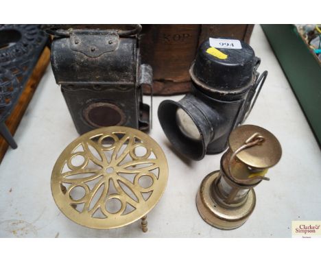 Two vintage lamps; a small reproduction miners lamp; and a brass trivet 