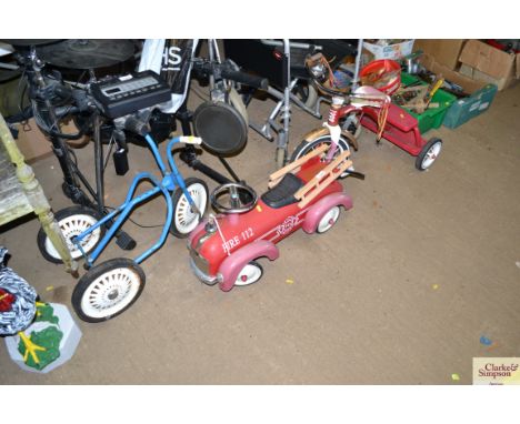 A children's toy fire engine and two tricycles