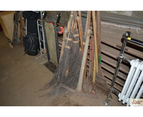 A collection of long handled garden tools; drain rods and brooms