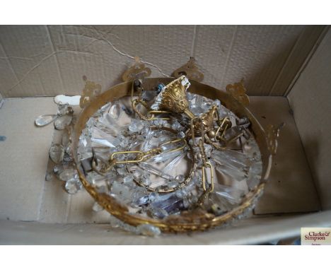 A brass light fitting with glass prism drops