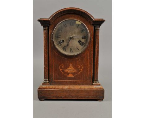 An inlaid oak cased H.A.C brand mantle clock, with an architectural case flanked with fluted columns, 33 cm high, 22 cm wide 