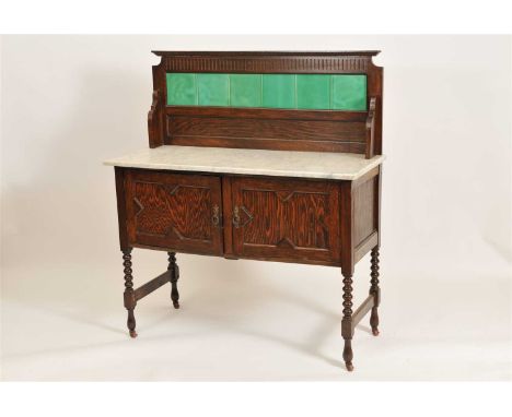 A marble topped Edwardian oak washstand, with a ceramic tiled pediment back above a white marble top above a pair of panelled