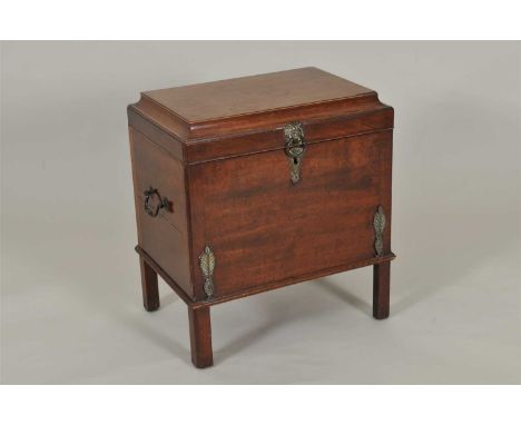 A George III mahogany cellarette, the hinged caddy top enclosing a ﬁtted interior with six bottle divisions, flanked with loo