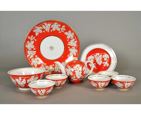 A Russian porcelain tea service decorated in bright orange with gilded leaves and grapes, comprising teapot and cover, five t