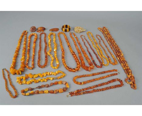 A collection of rough amber, comprising; ten rough and polished fragment necklaces, three spherical bead necklaces, two gradu