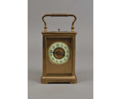 An Edwardian brass cased carriage clock, with a disk dial populated with black Roman numerals, 13 cm high, 8.5 cm wide.