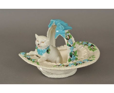 A Victorian porcelain model of a kitten seated in a basket, possibly Brownfield, the basket adorned with blue flowers and gre
