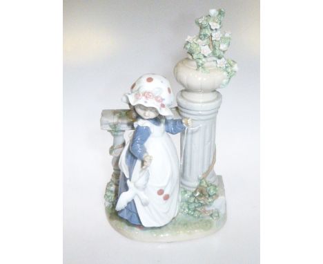 Lladro figure of girl with dove standing by garden balustrade mounted with urn