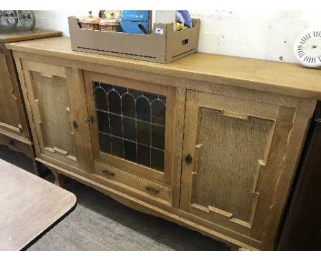 A continental oak triple door sideboard with leaded glass panel 