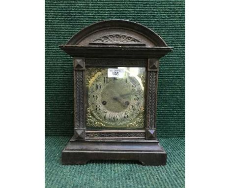A late nineteenth century oak fourteen day strike mantle clock with brass face