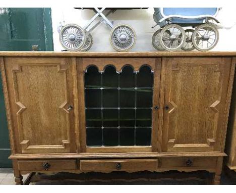 A continental oak triple door sideboard with leaded glass panel 