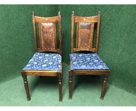 A pair of late Victorian oak dining chairs inset with leather panel 