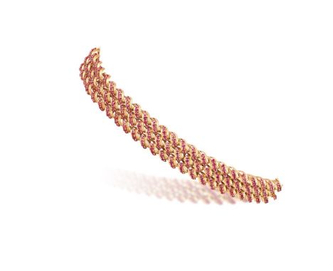 A RUBY AND GOLD BRACELET, BY TIFFANY & CO., CIRCA 1960Composed of three rope-twist bands, each link highlighted by circular-c